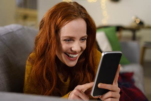 Frau bewertet eine Gastronomie am Smartphone