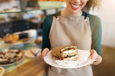 Kellnerin präsentiert Sandwich