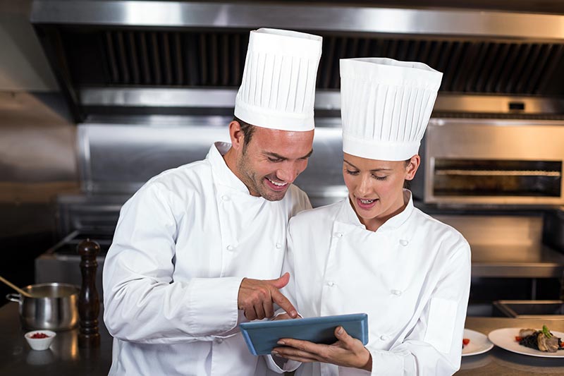 2 Köche schauen am Tablet auf die Werbung von CHEFS CULINAR